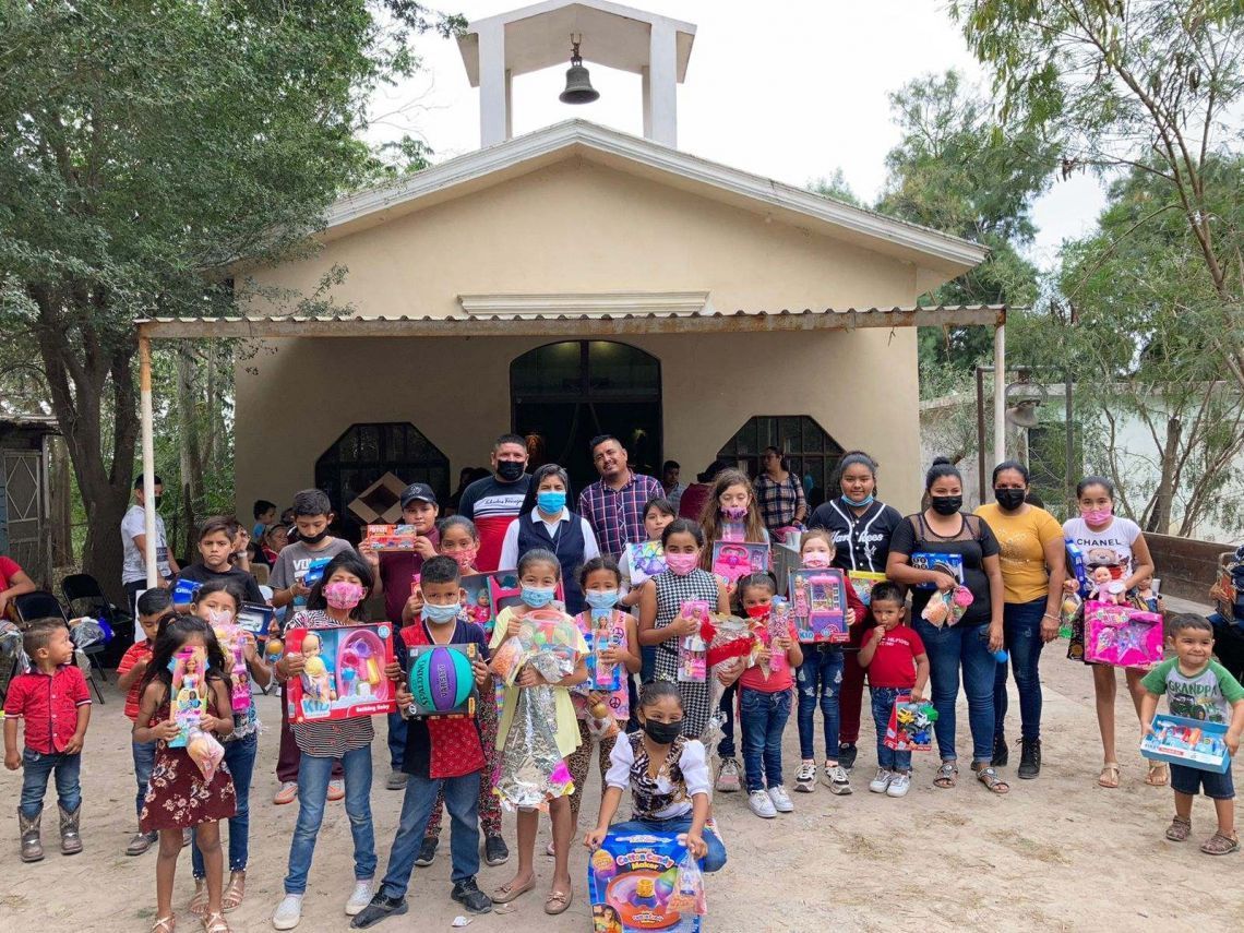 A group of children are posing for a picture in front of a church.