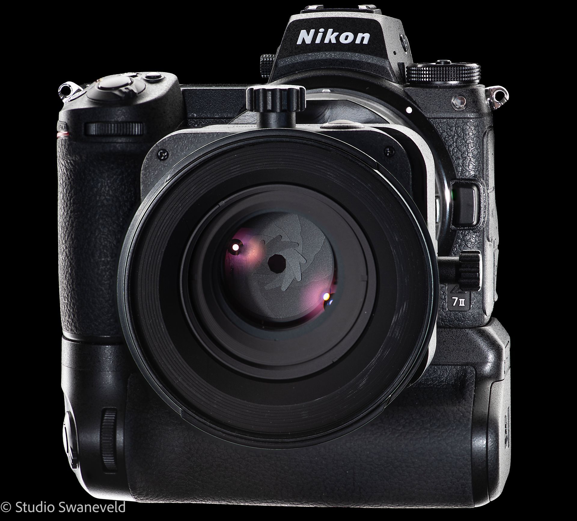 Nikon-camera met lens, bevestigd aan een batterijgrip. Zwarte behuizing tegen een zwarte achtergrond.