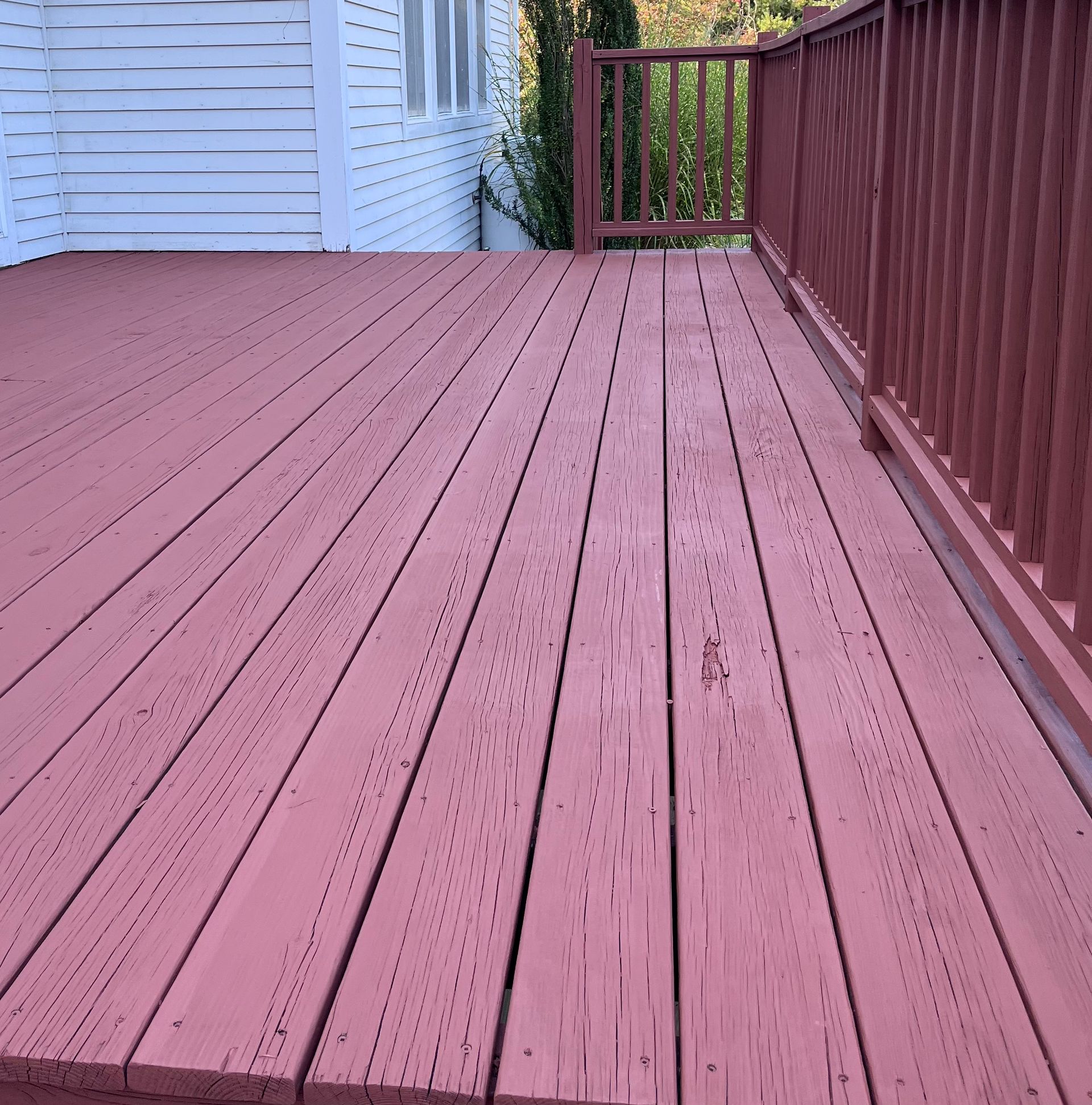 A red deck with a white house in the background