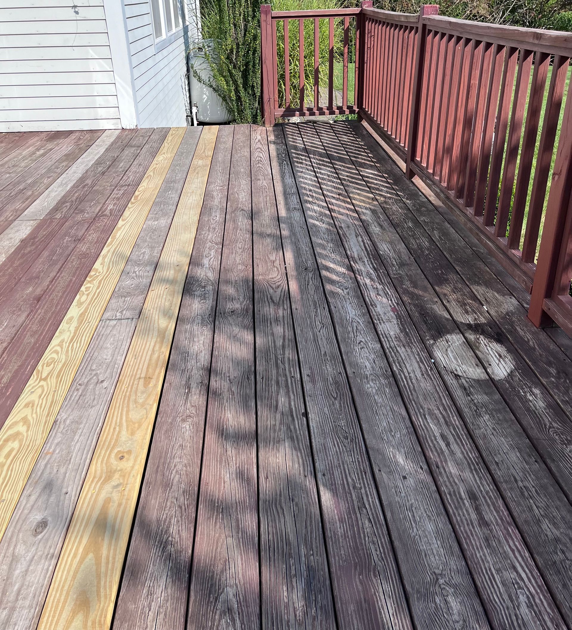 A wooden deck with a red railing and yellow lines