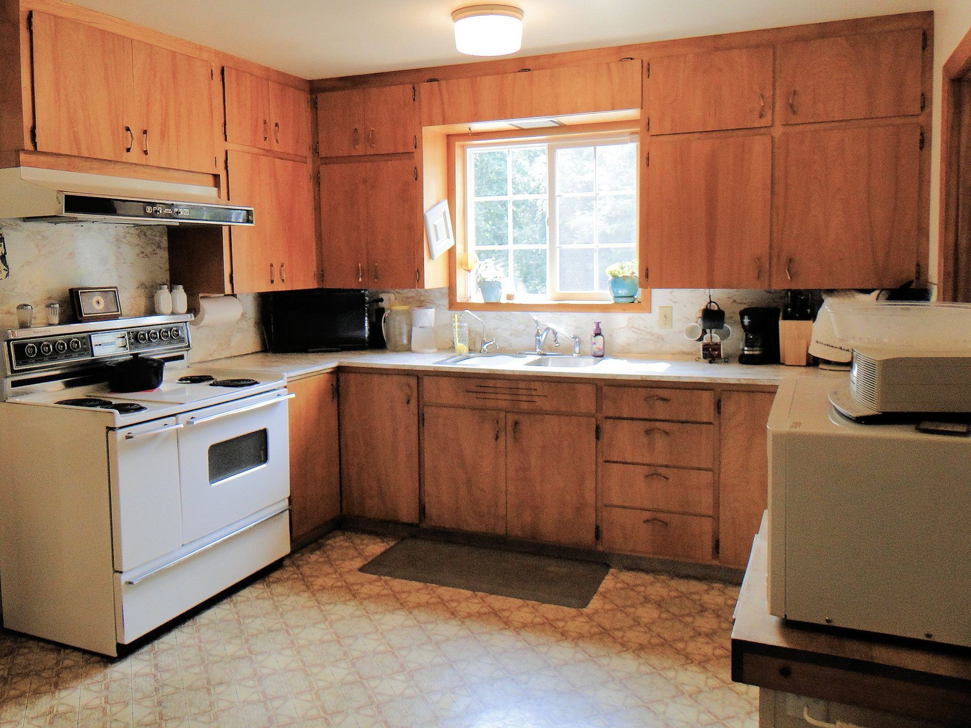 A kitchen with wooden cabinets and a white stove