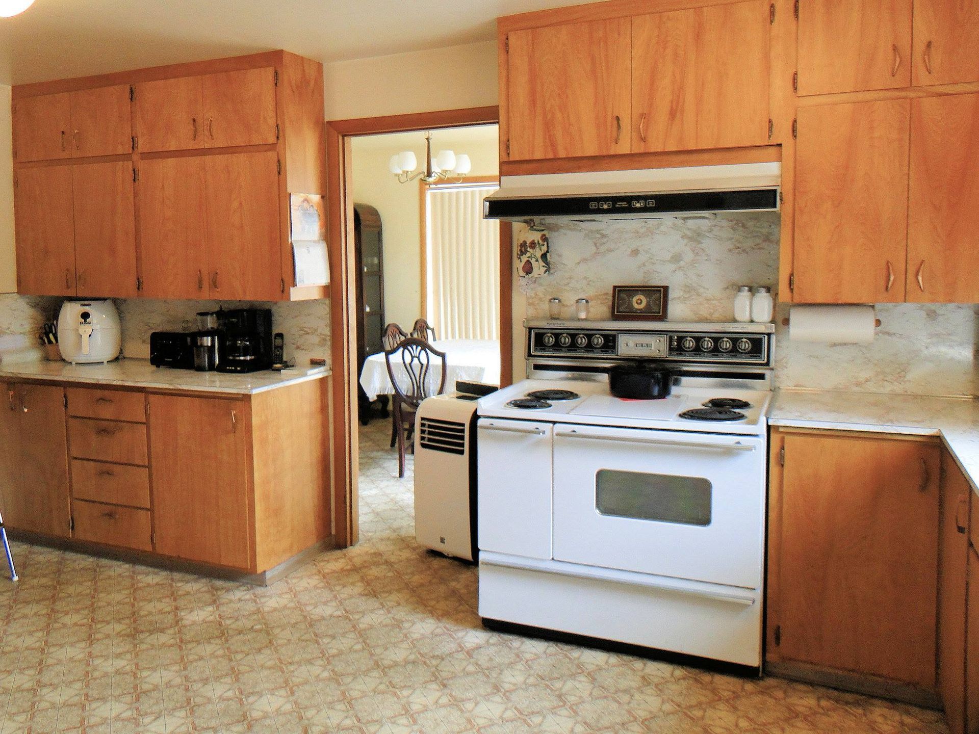 A kitchen with wooden cabinets and a white stove