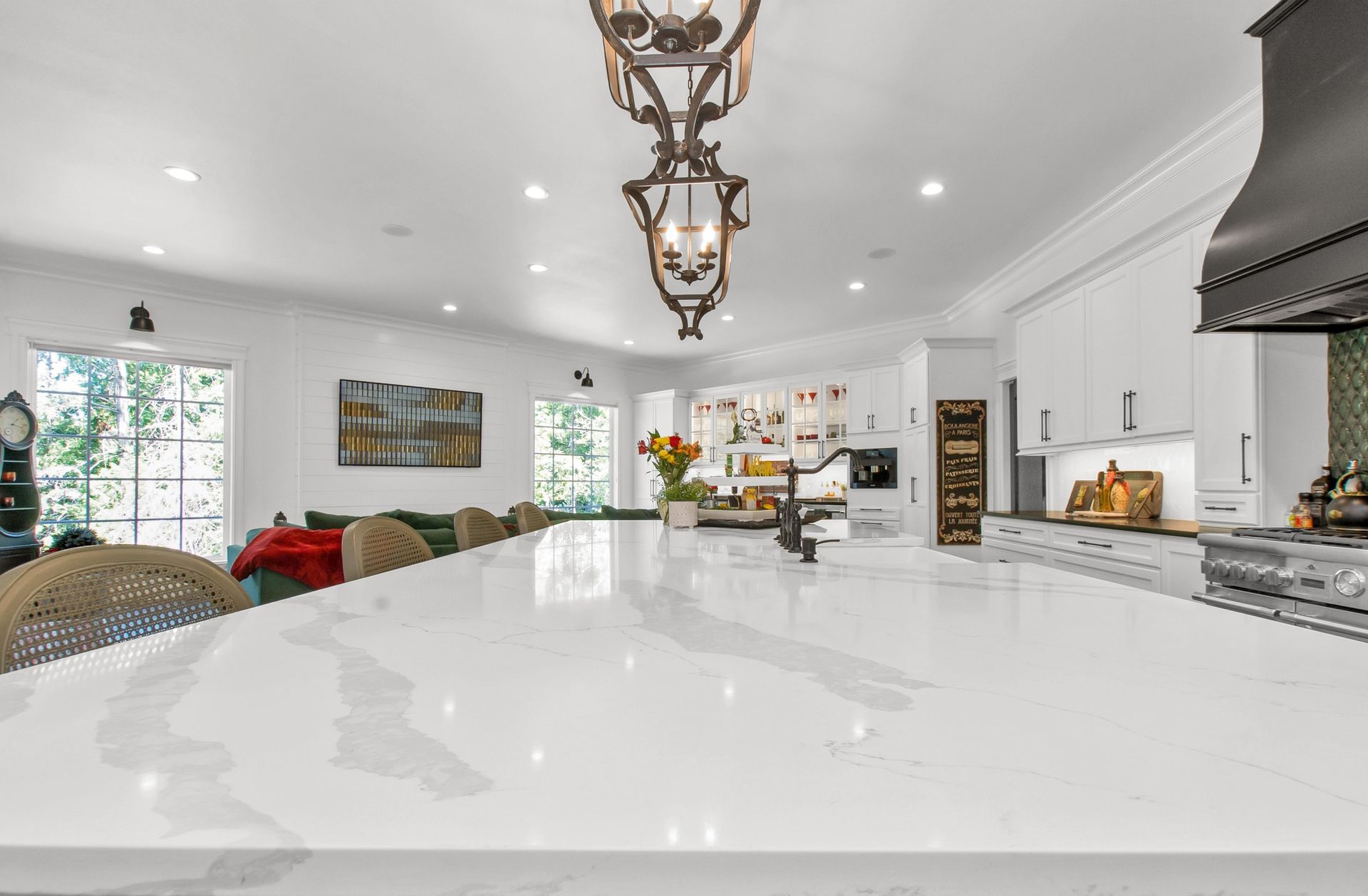 A kitchen with a large island and a chandelier hanging from the ceiling.