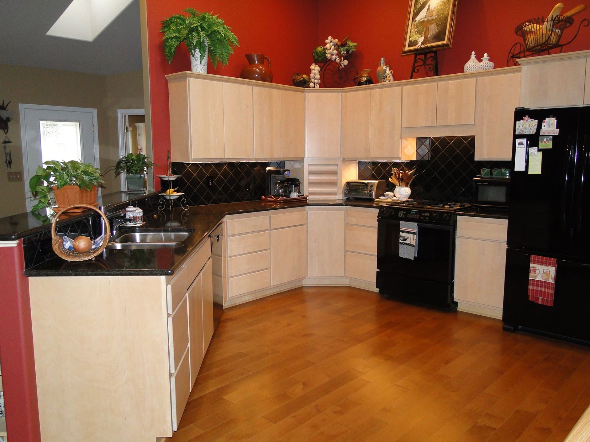 A kitchen with wooden cabinets and a black refrigerator