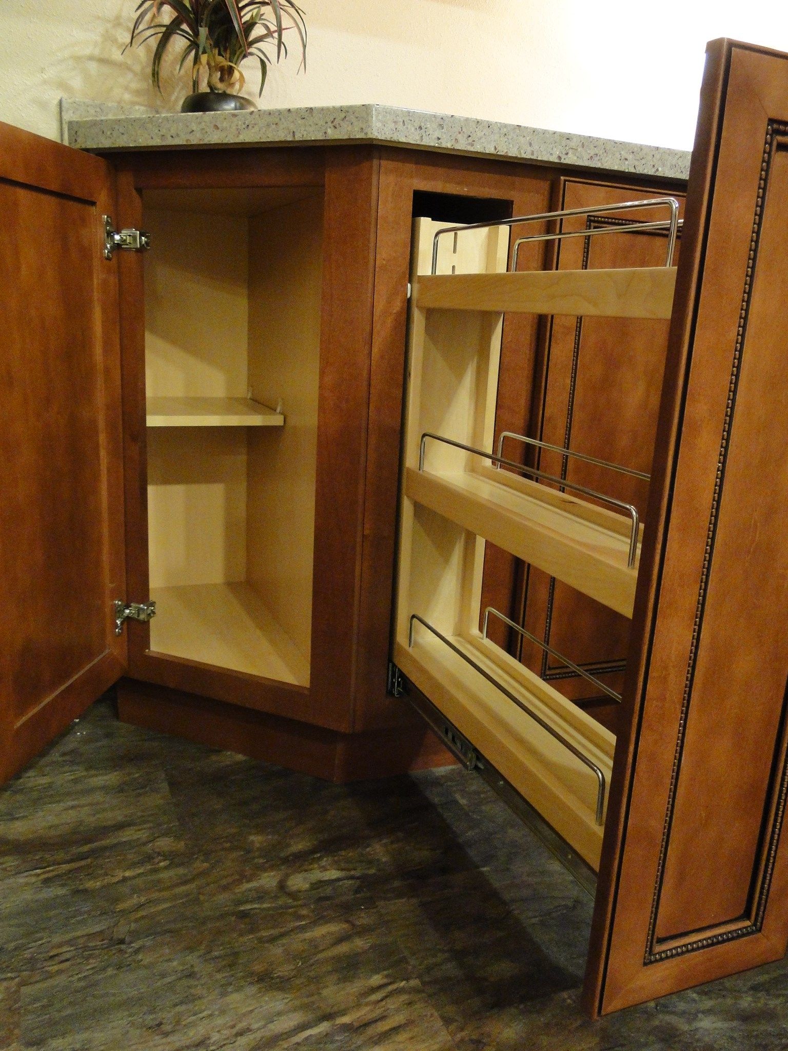 A kitchen cabinet with a pull out spice rack