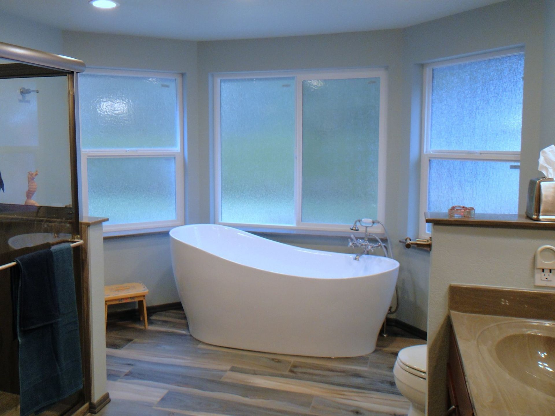A bathroom with a tub , toilet , sink and shower.