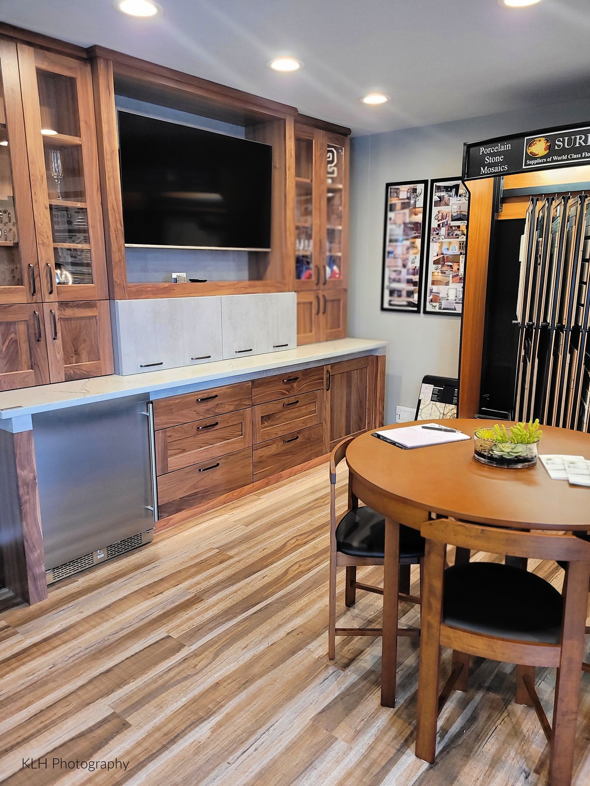 A dining room with a table and chairs and a flat screen tv.