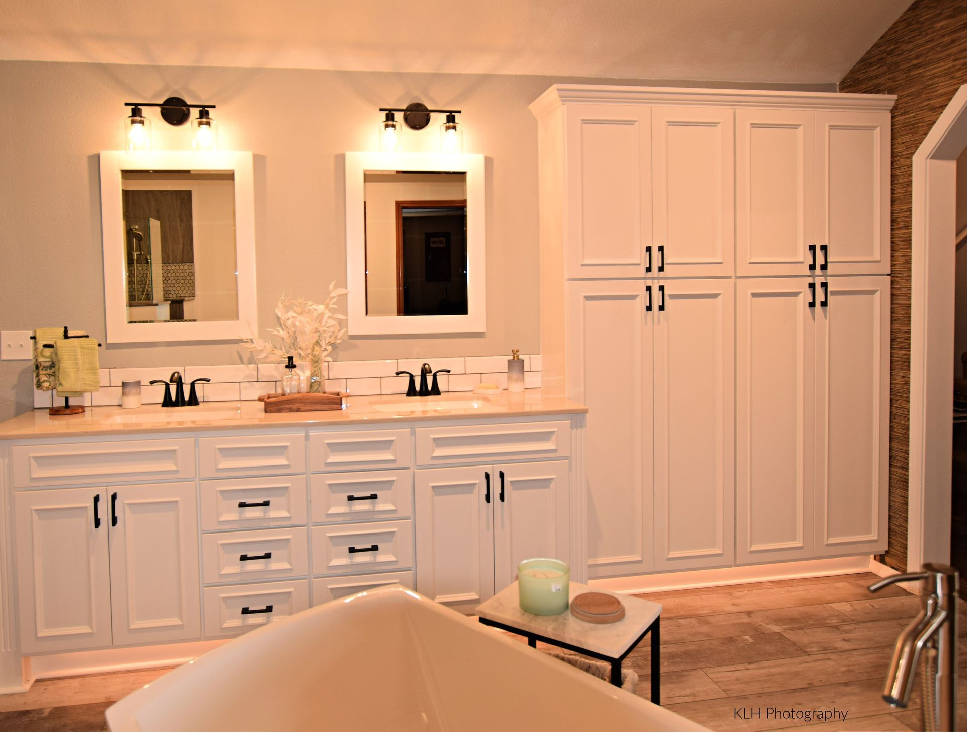 A bathroom with two sinks , two mirrors , and a bathtub.