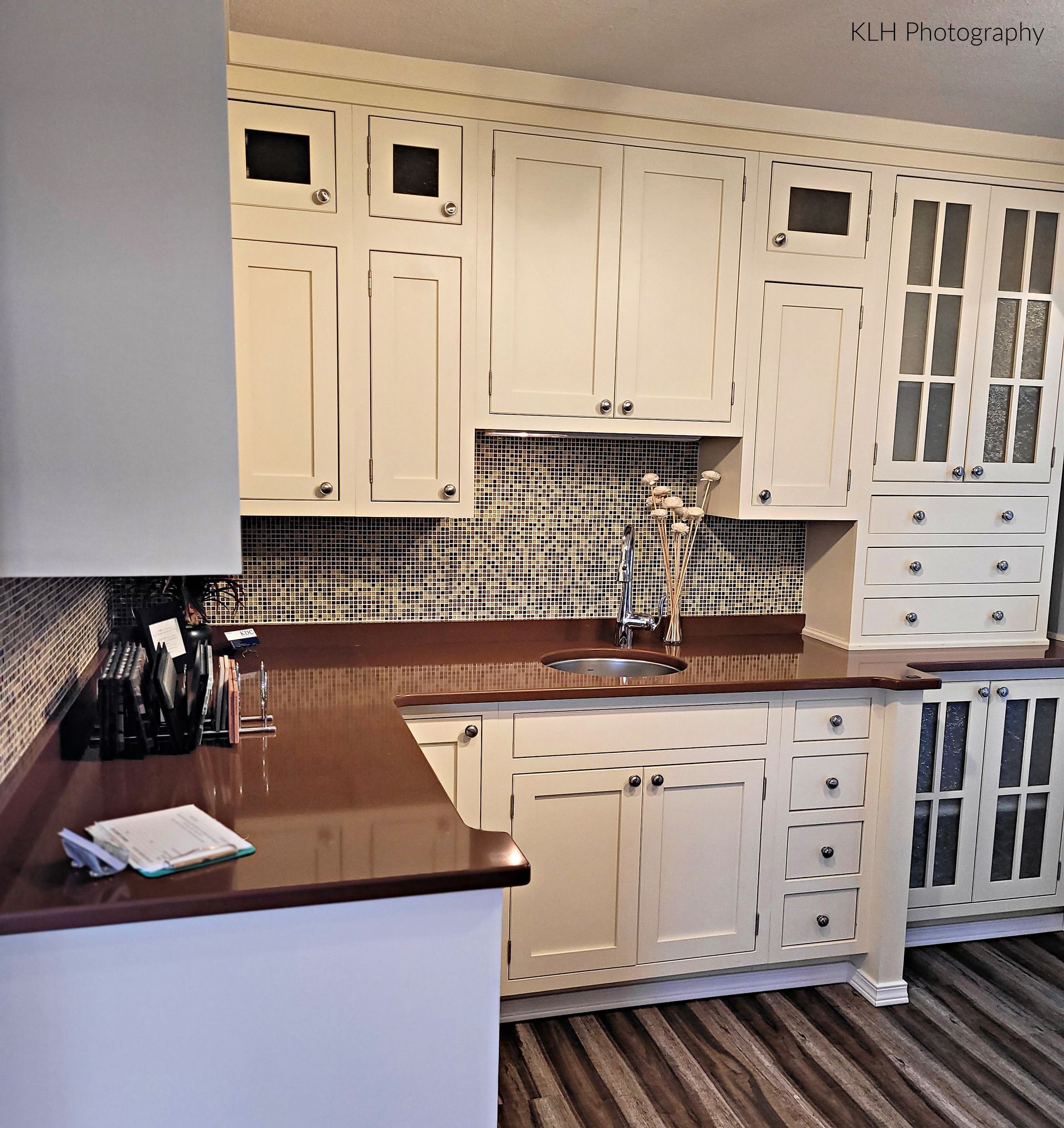 A kitchen with white cabinets and a brown counter top
