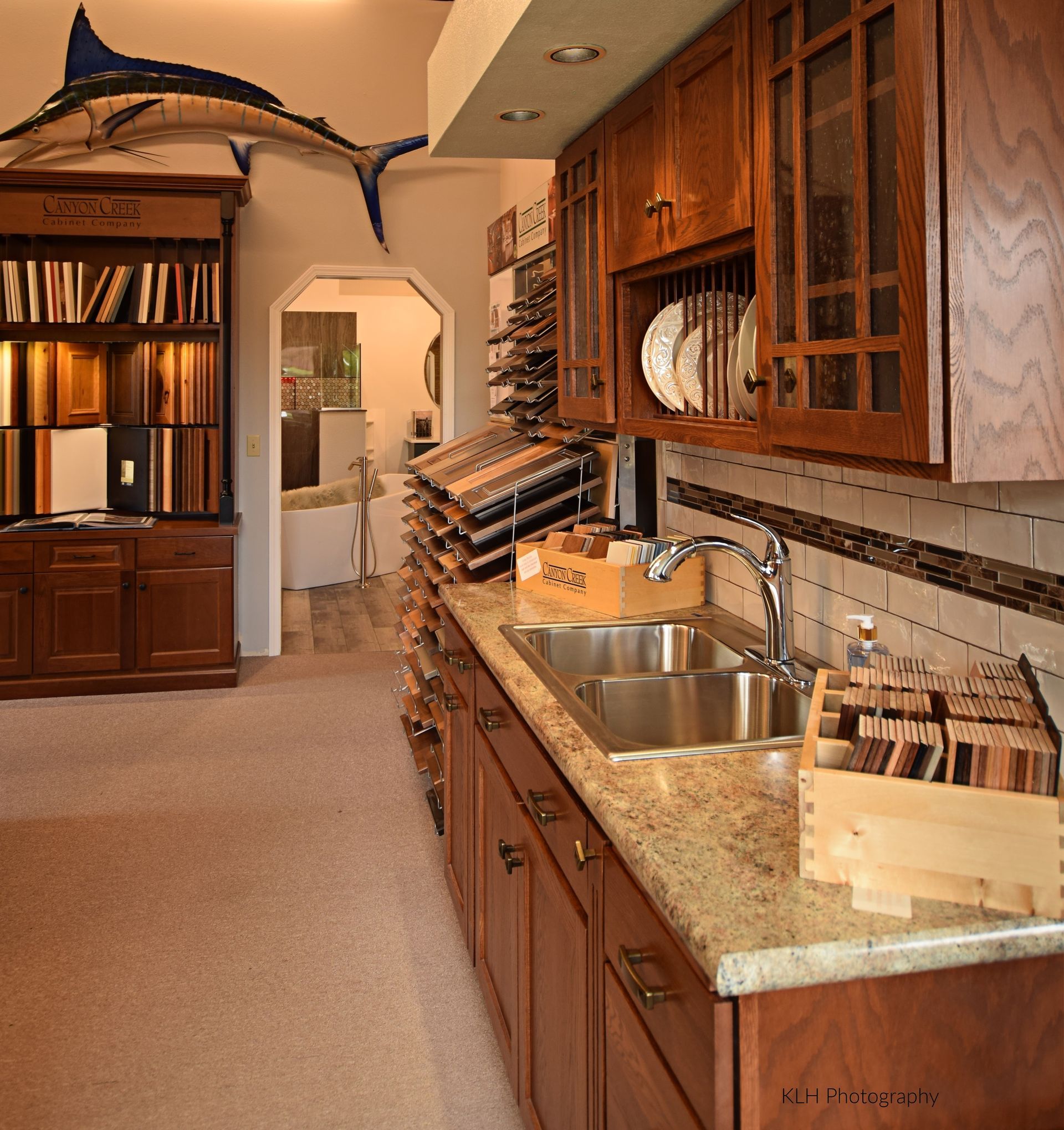 A kitchen with a sink and a fish hanging from the ceiling