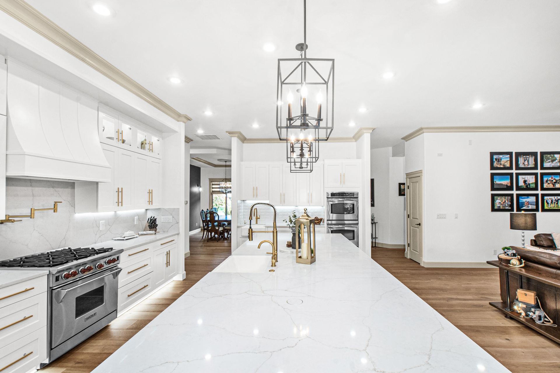 A kitchen with white cabinets , stainless steel appliances , and a large island.