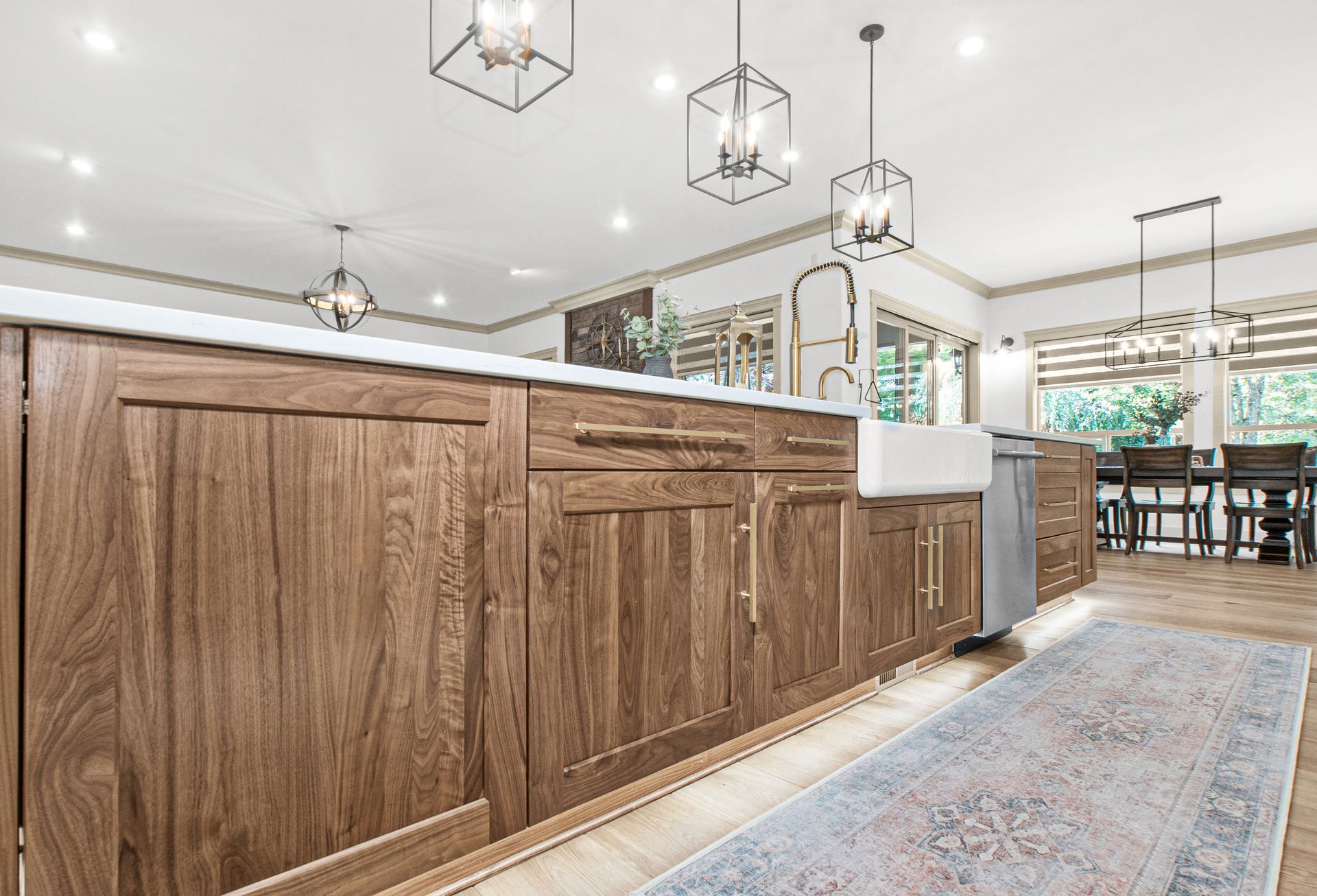A kitchen with wooden cabinets , a sink , and a rug.