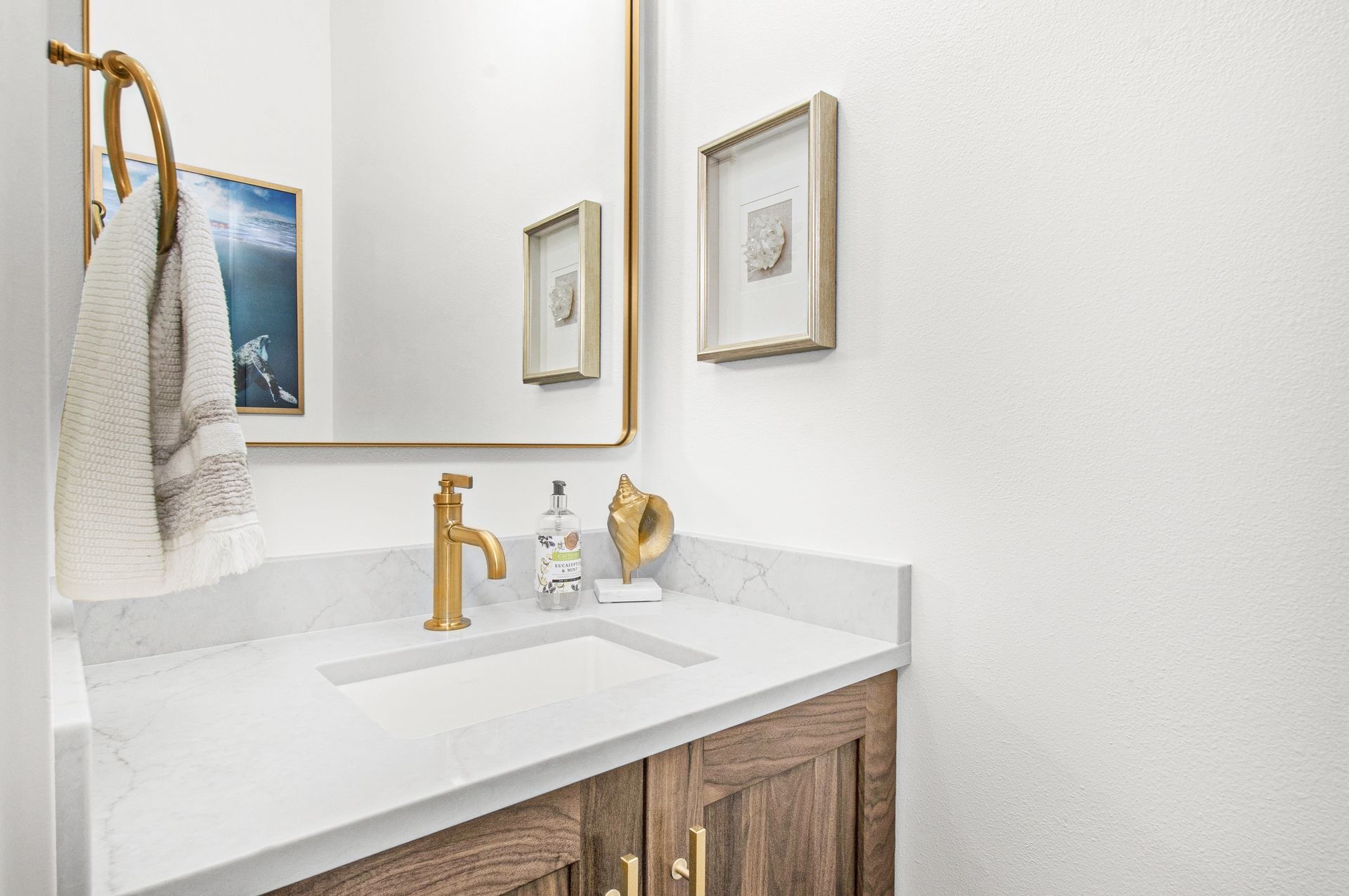 A bathroom with a sink , mirror and towel rack.