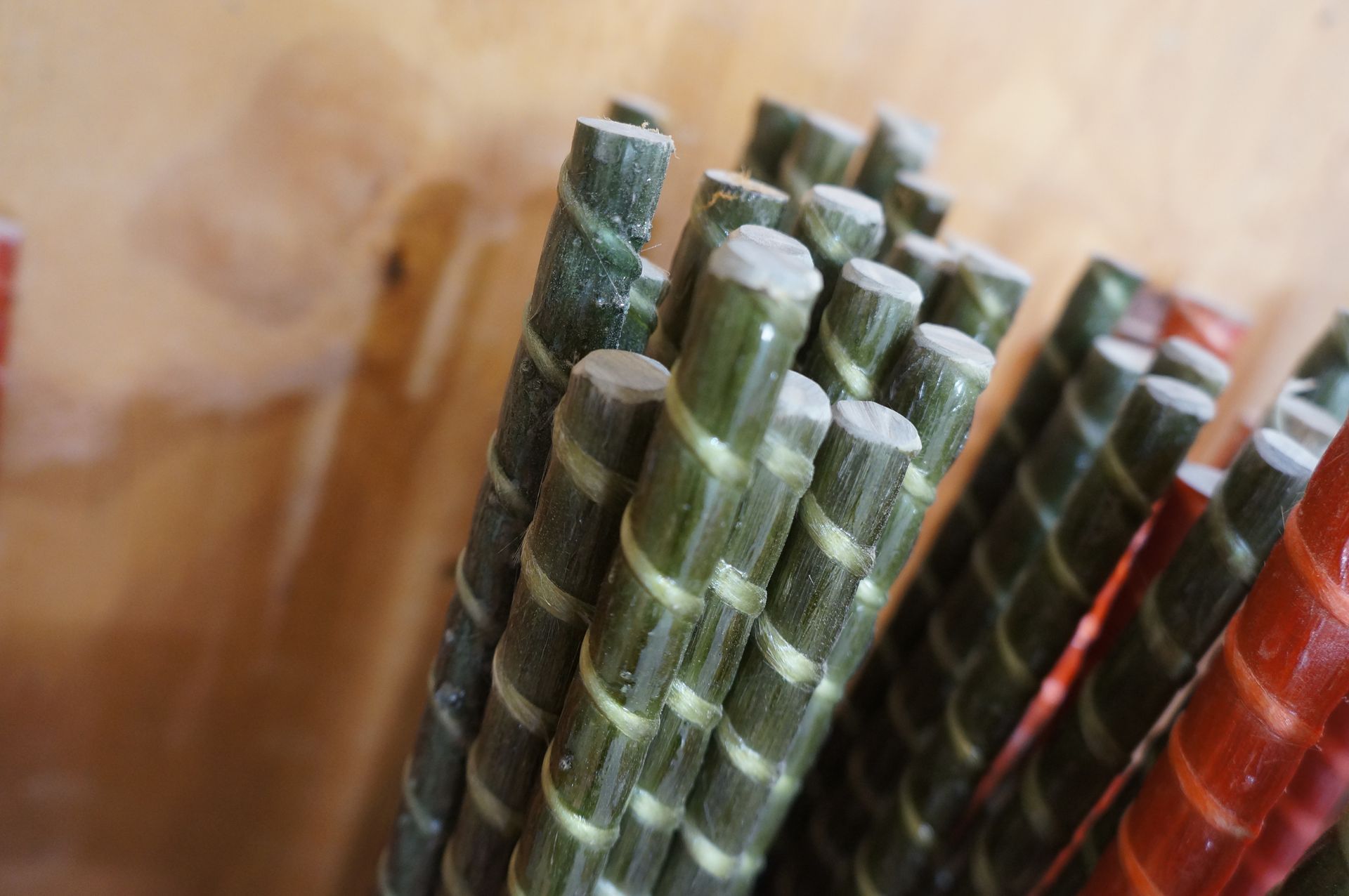 Bundle of green and red fiberglass rebar with spiral ridges, ready for construction.