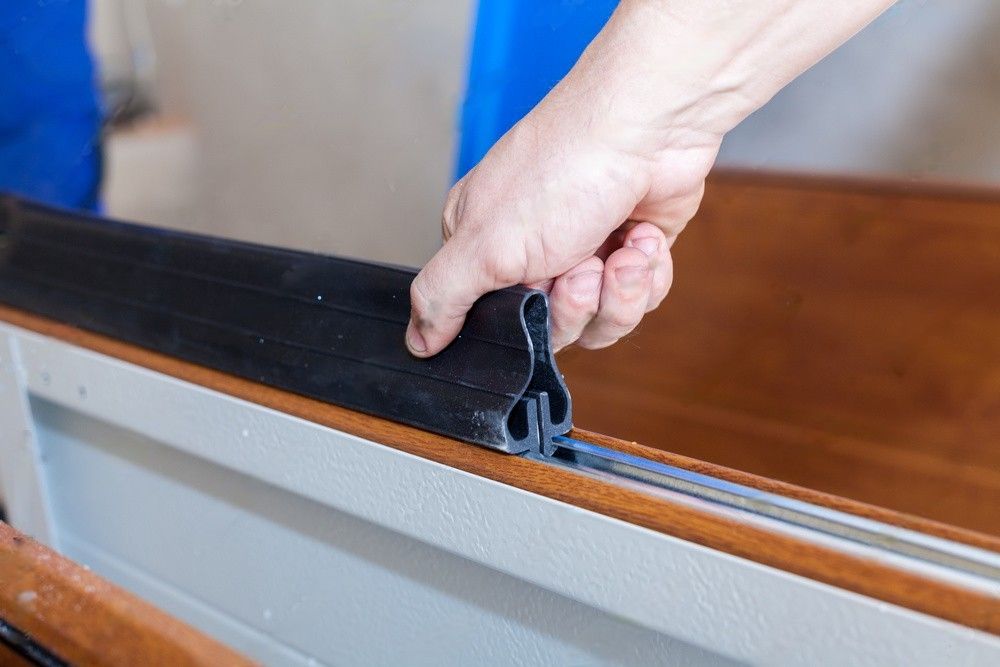 A person is holding a piece of rubber on a wooden surface.