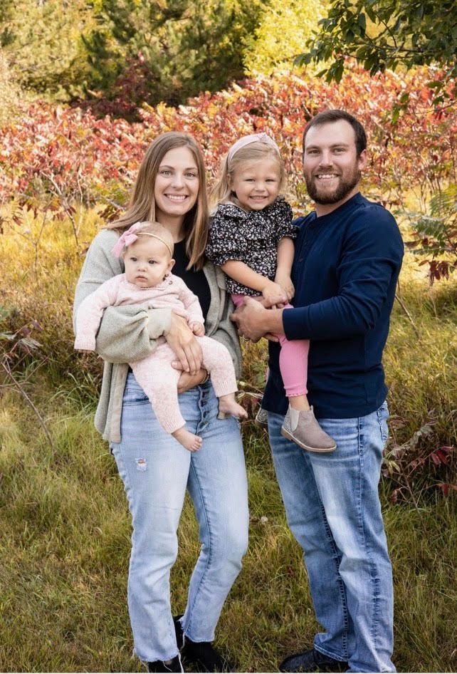 A family is posing for a picture in a field.