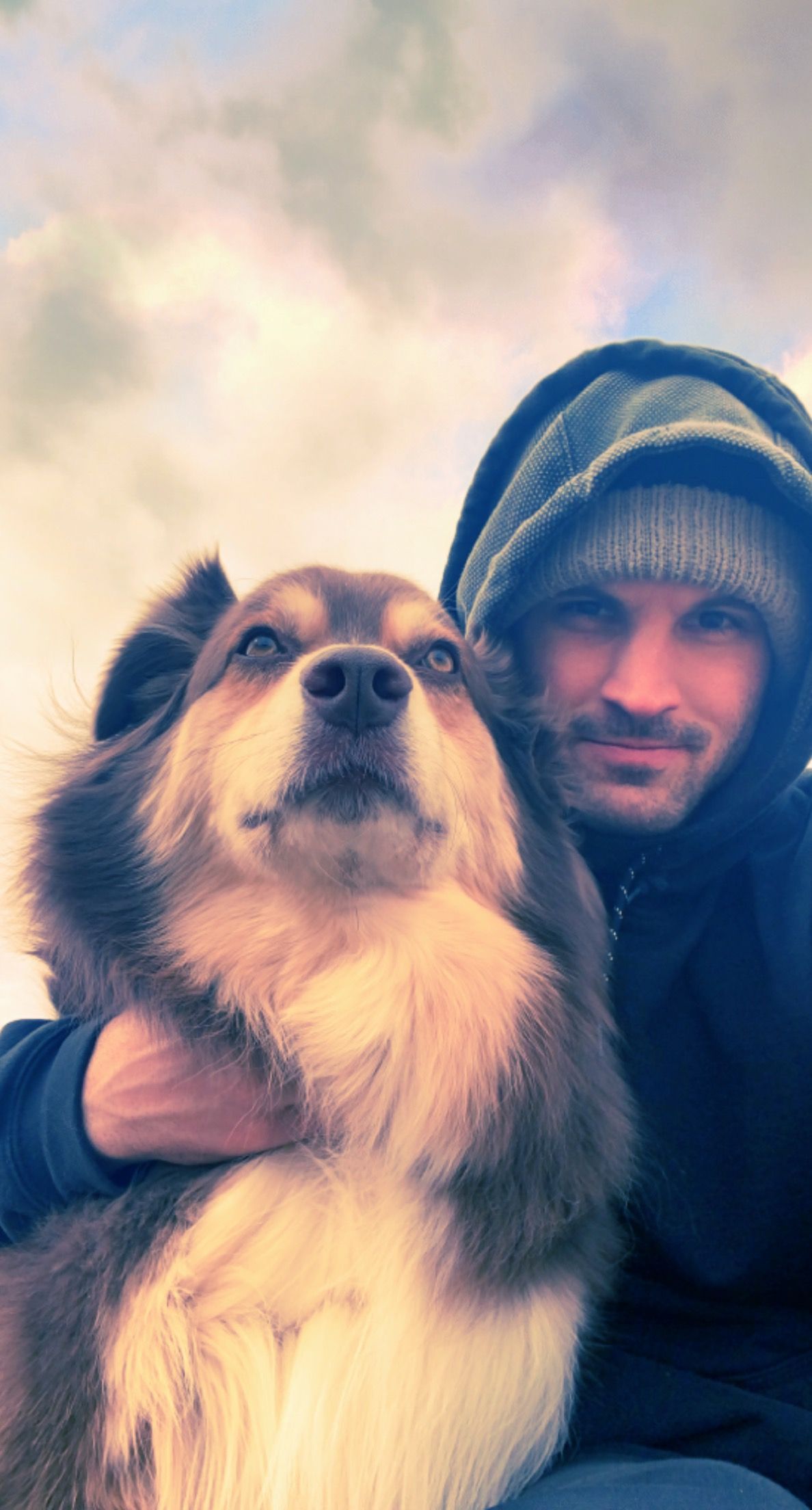 A man is holding a large dog in his arms.
