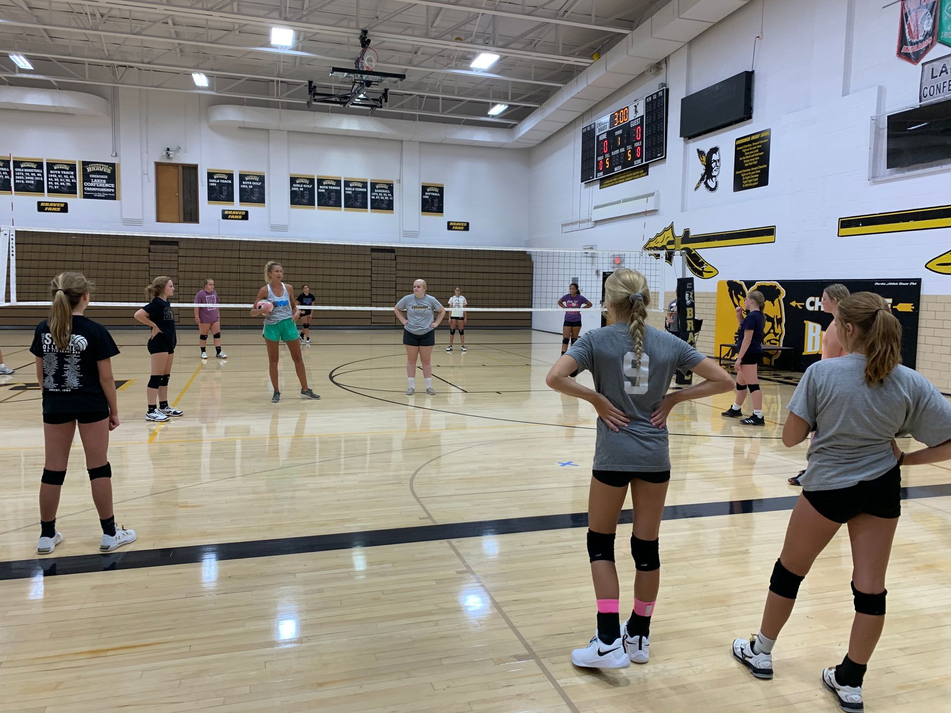 A group of girls are playing volleyball in a gym.
