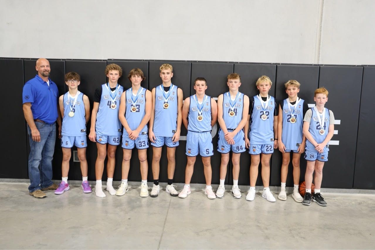 A basketball team is posing for a picture with their coach.