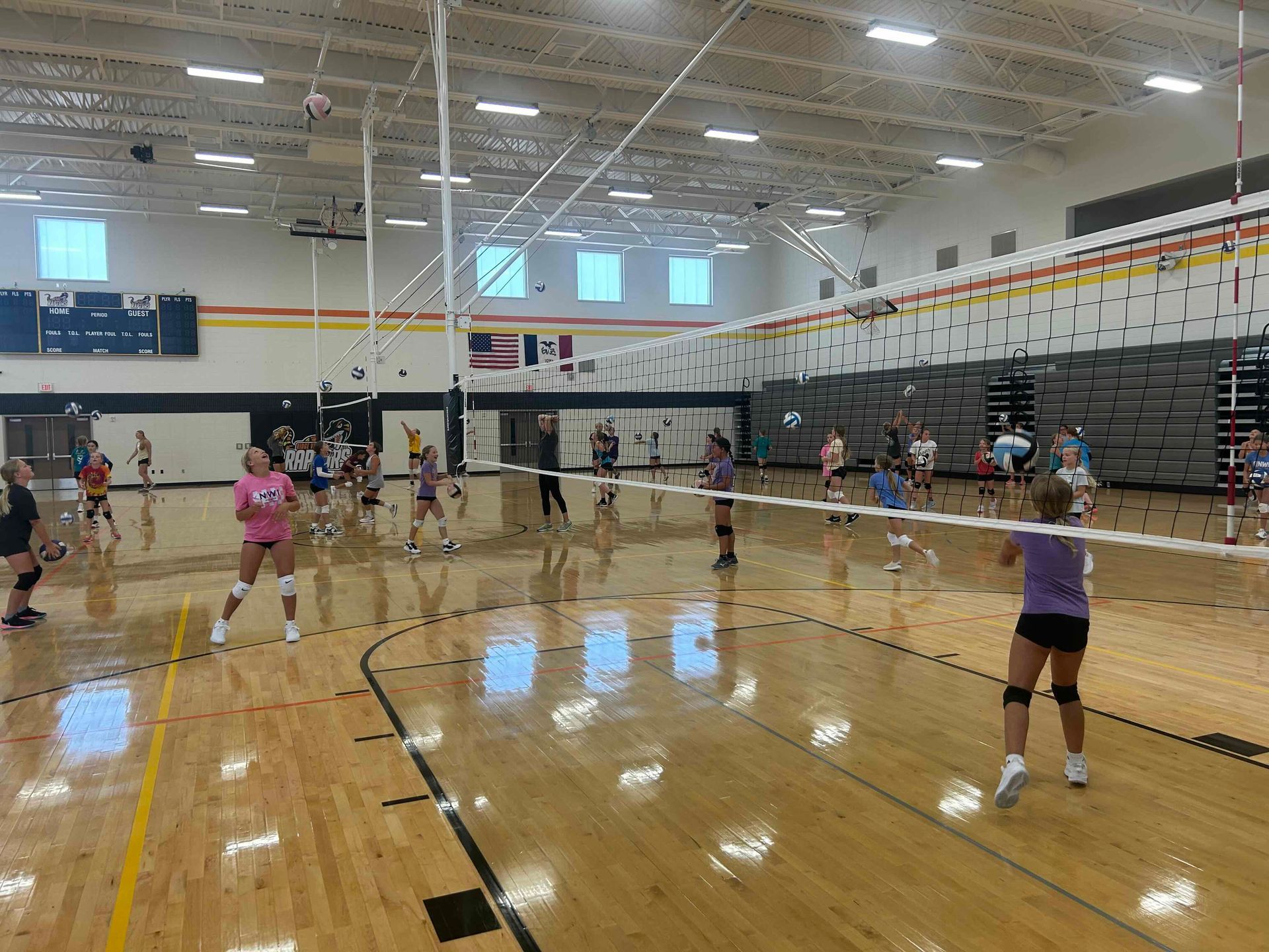 A group of volleyball players are standing in a gym.