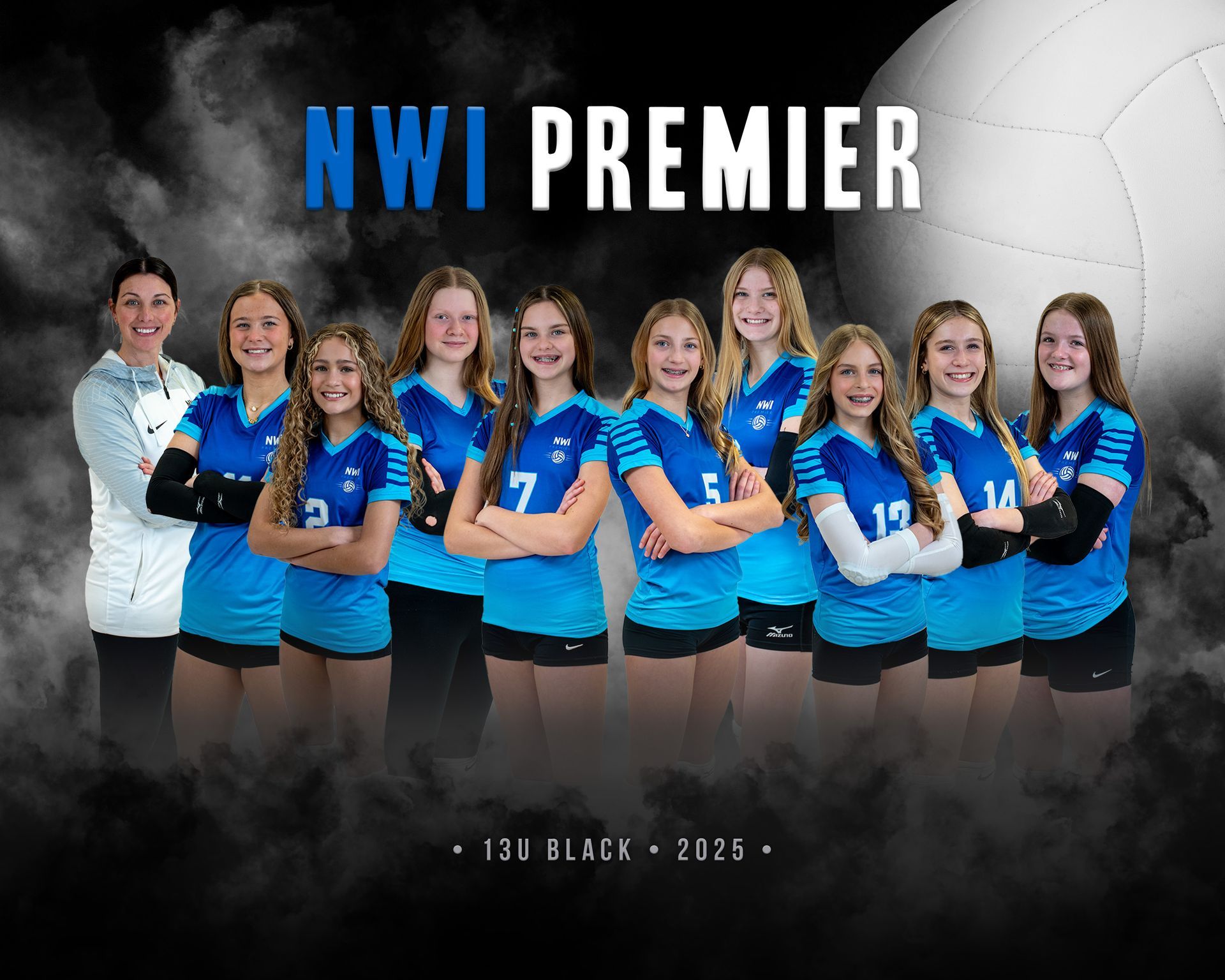 A volleyball team is posing for a picture in a gym.
