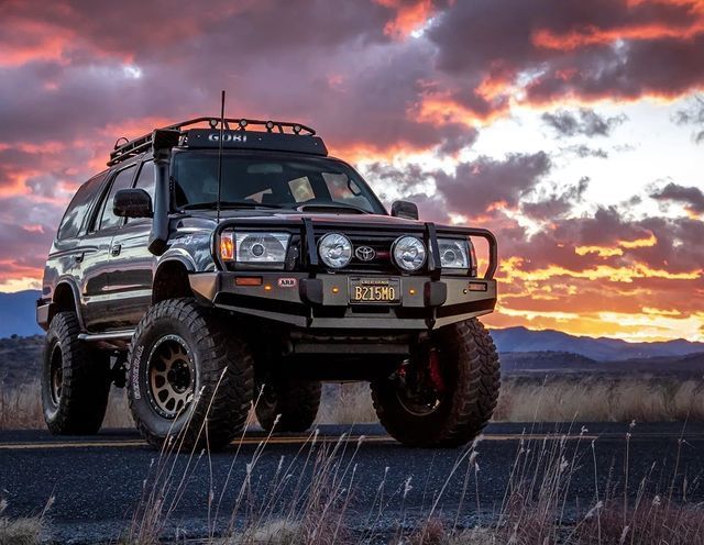 A toyota 4runner is parked on the side of the road at sunset.