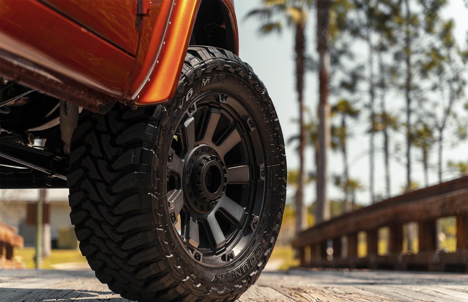 A close up of a truck wheel on a dirt road