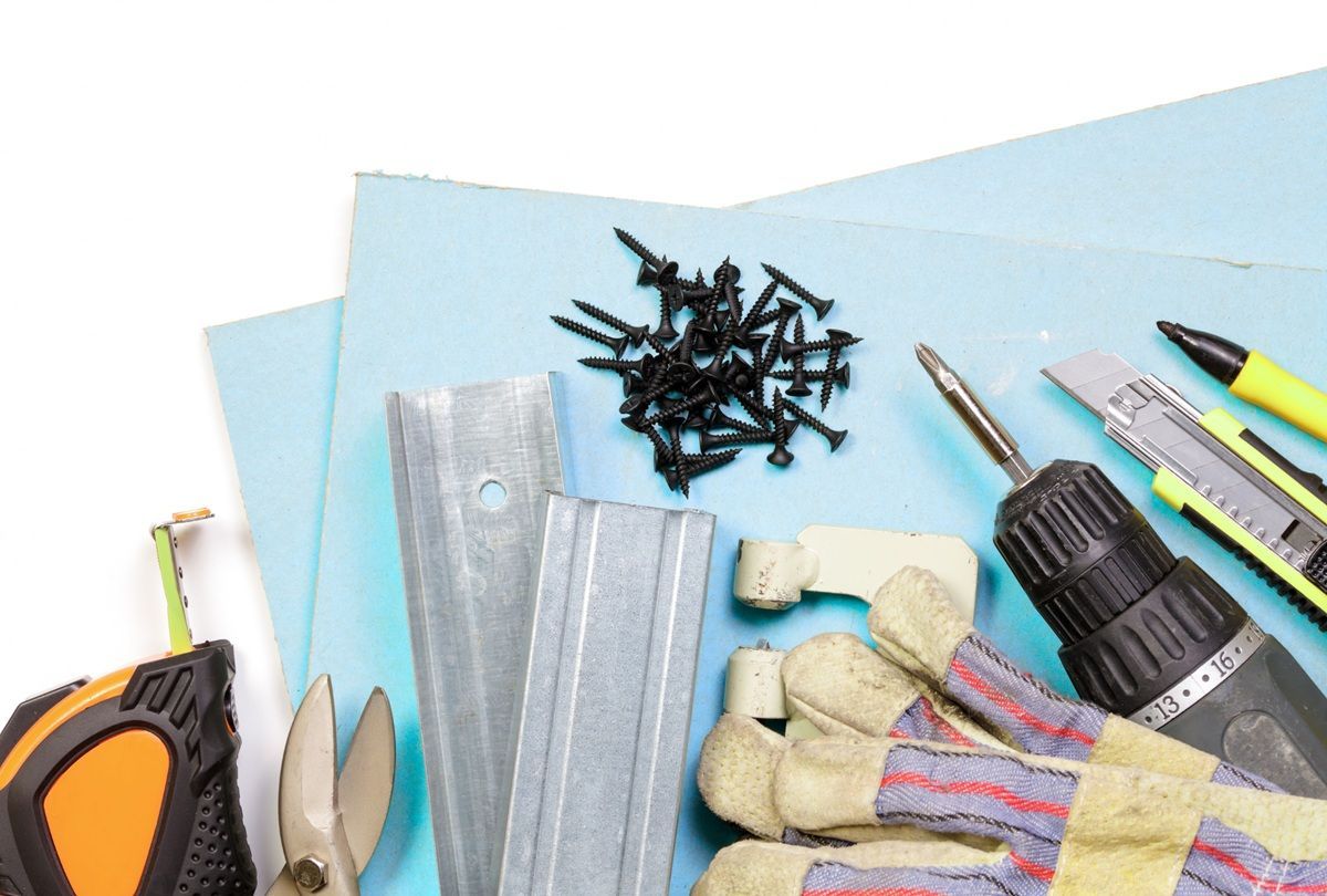 Drywall technician using professional repair tools in Tulare