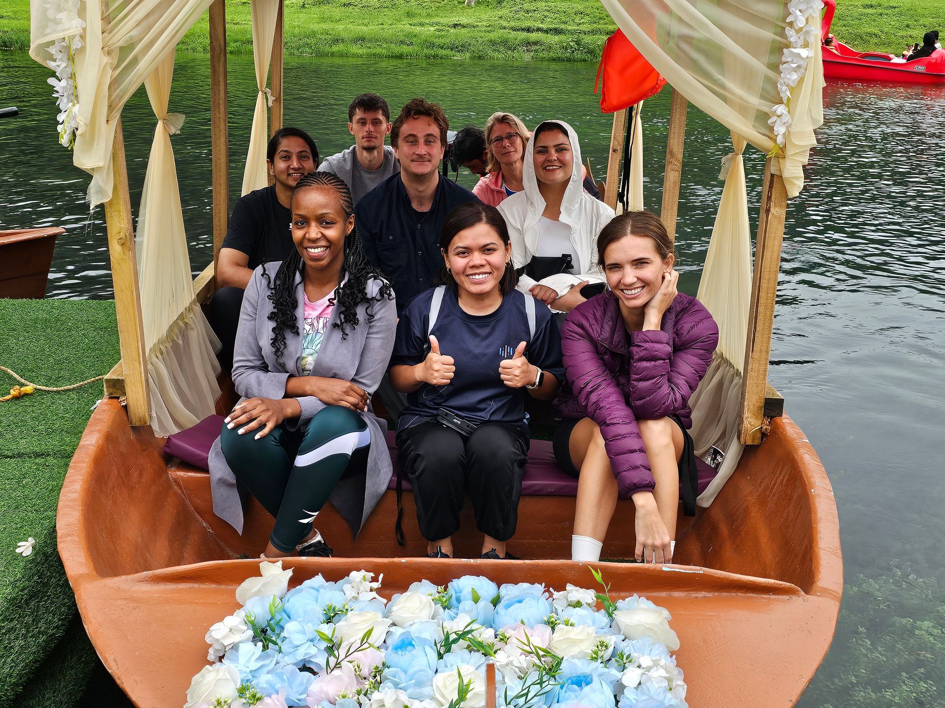 Arabian Wanderers travelers enjoying a traditional boat ride on the peaceful waters of Wadi Darbat in Salalah, Oman, during the lush Khareef season