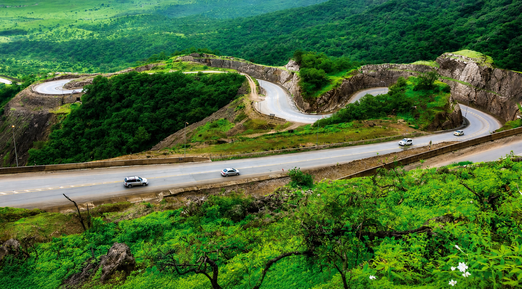 Scenic winding mountain road through the lush Dhofar Mountains near Wadi Darbat in Salalah during the Khareef season