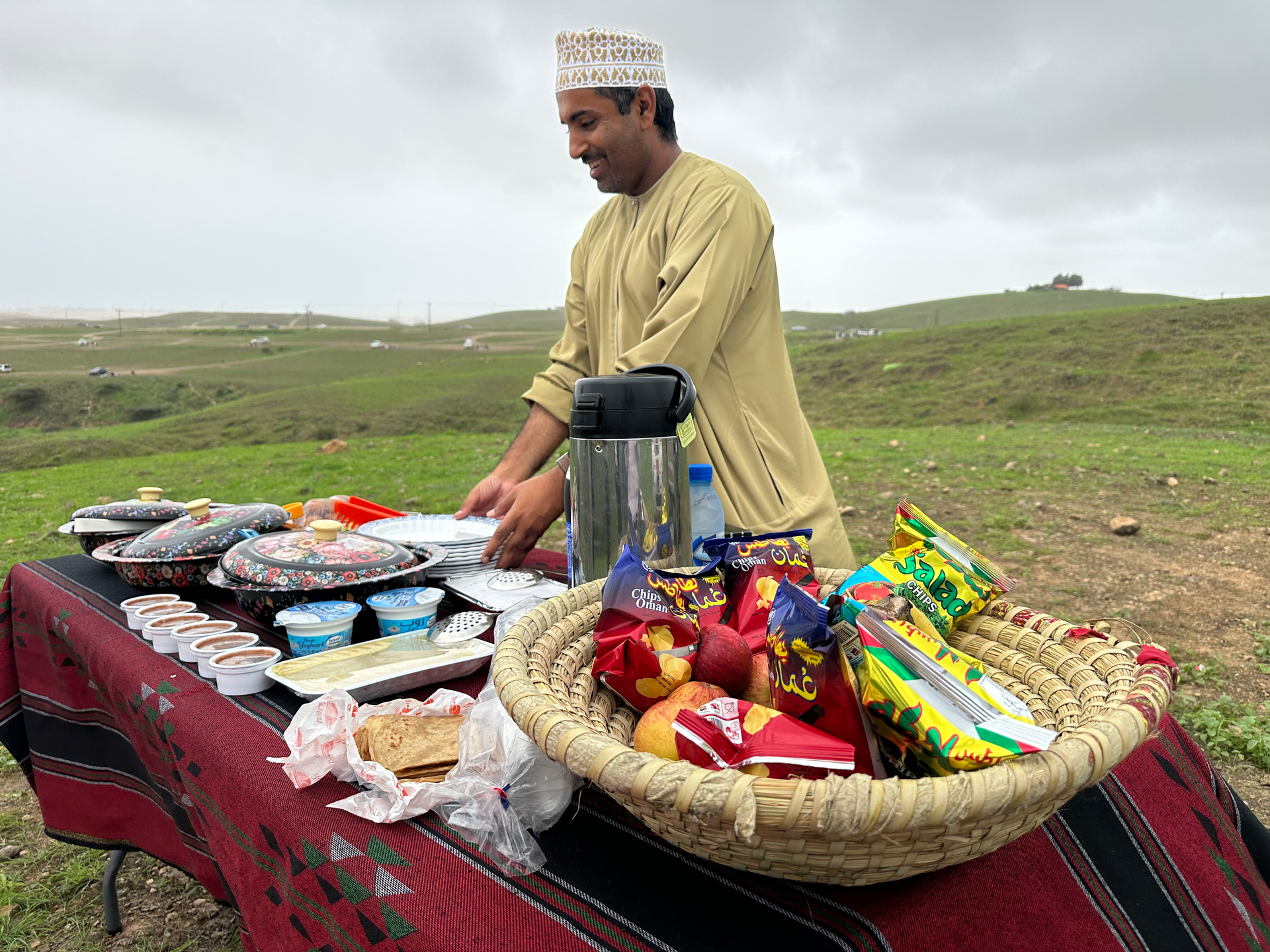 Arabian Wanderers' local guide serving food in a picnic in the outdoors in Salalah.