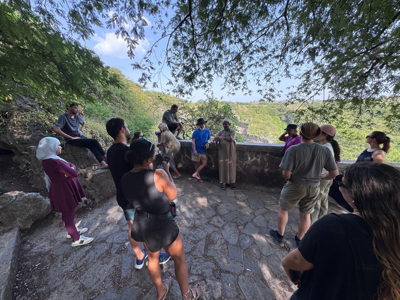 Arabian Wanderers guide and a group of travelers standing at a beautiful viewpoint in salalah