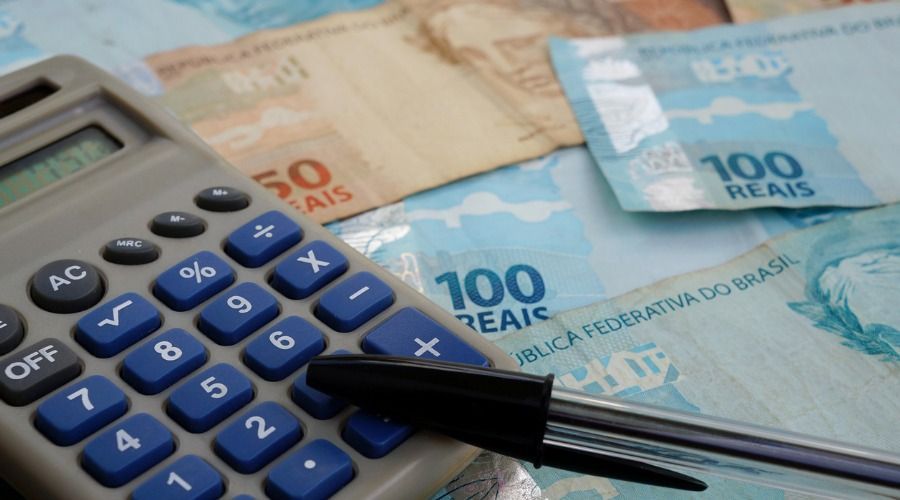 Uma calculadora está em cima de uma pilha de dinheiro.