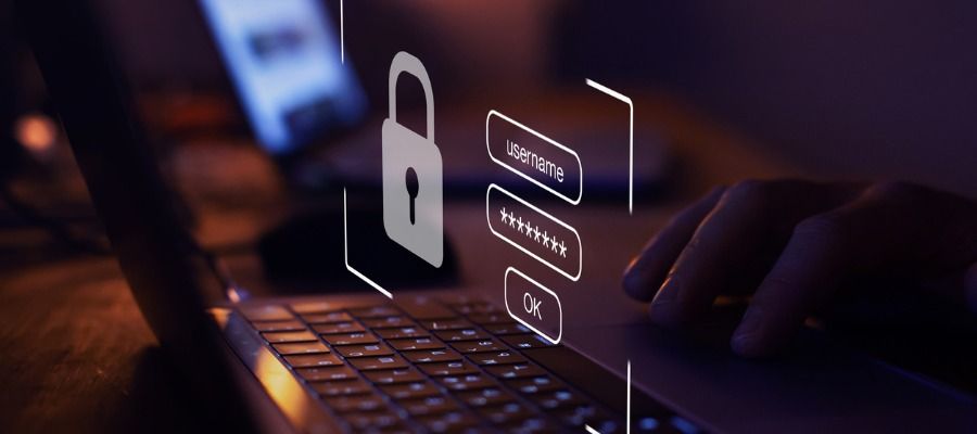 Uma pessoa está digitando em um laptop com um cadeado saindo da tela.
