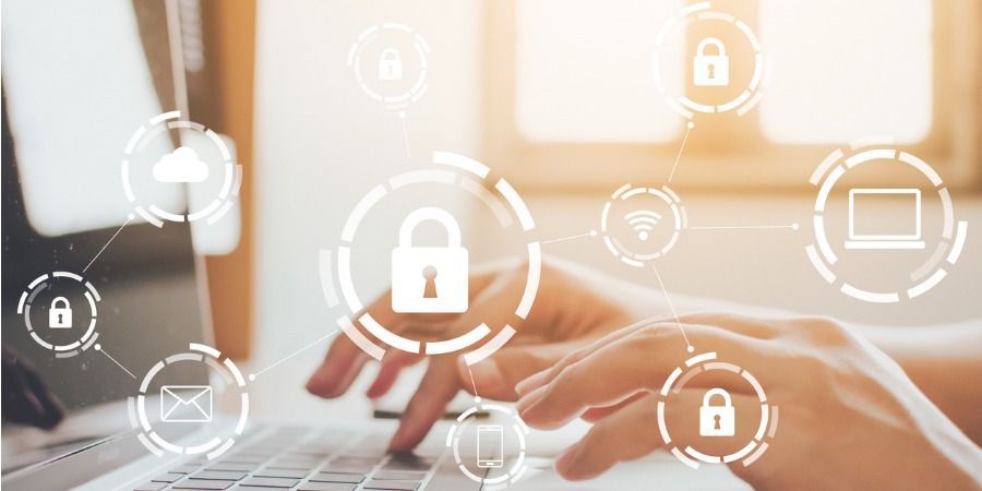 Uma pessoa está digitando em um laptop com um cadeado na tela.