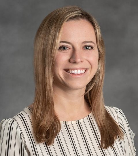 A woman in a striped shirt is smiling for the camera.