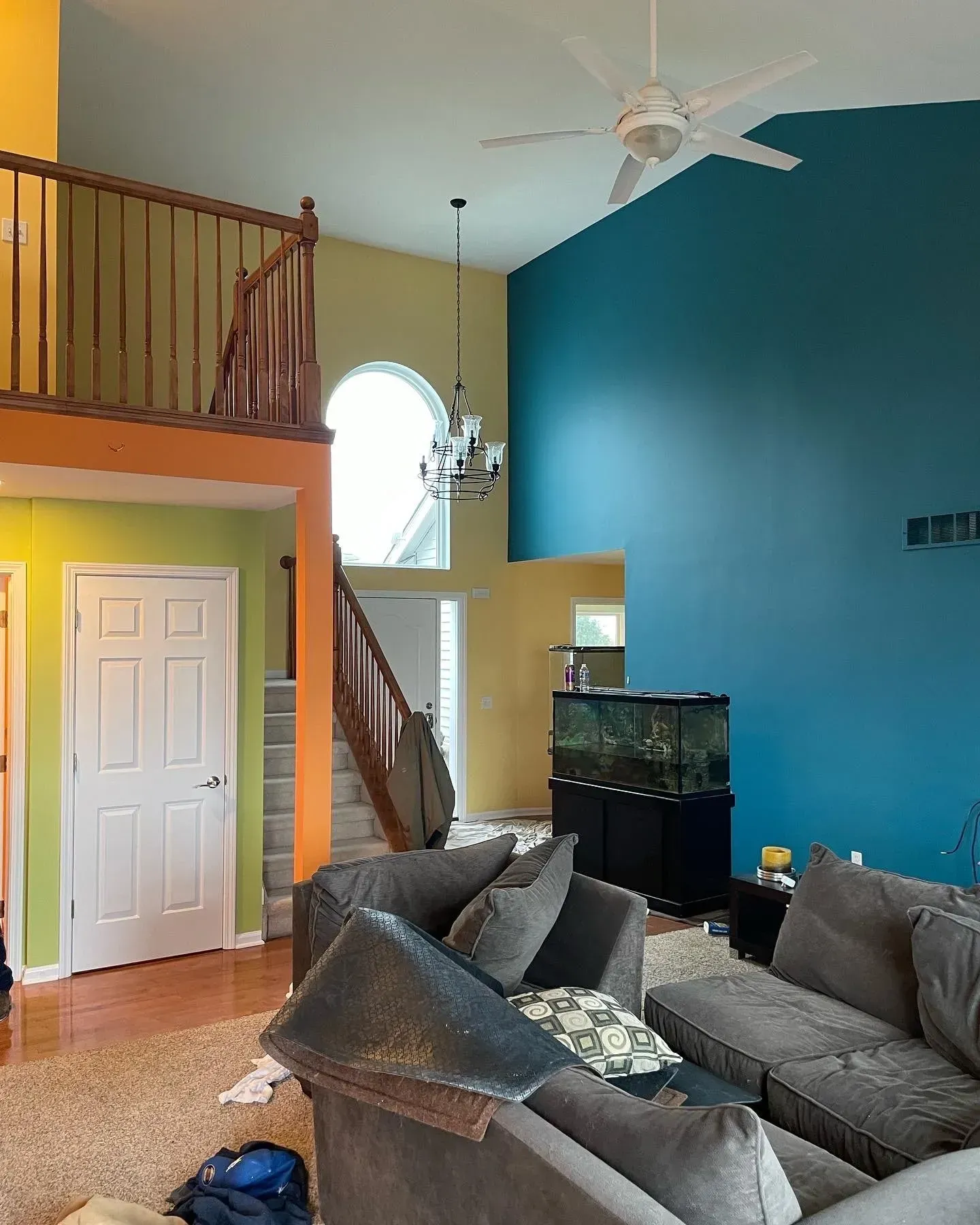 A living room with blue walls and a ceiling fan