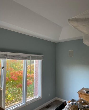 A bedroom with a lot of windows and a ceiling fan.