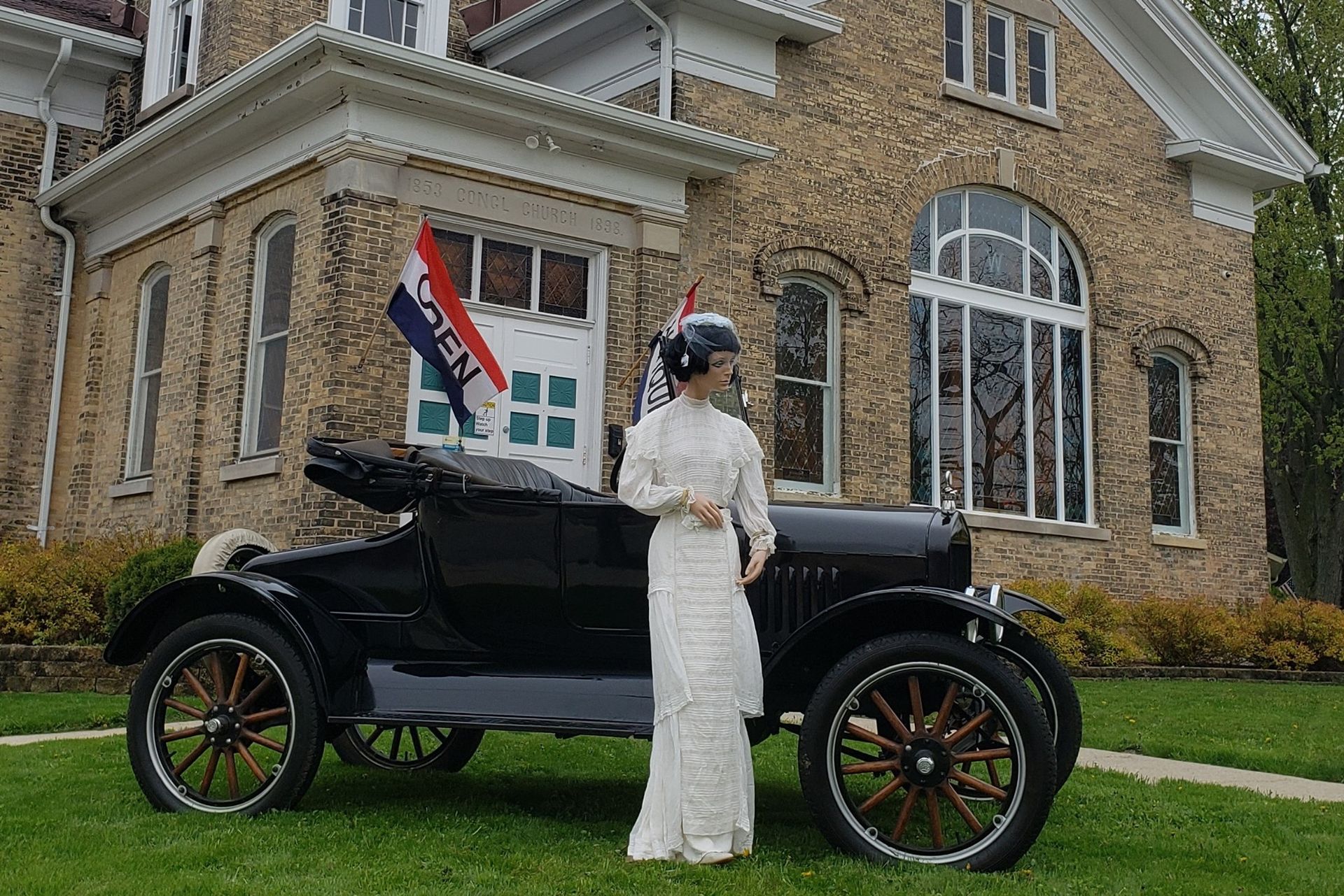 Exterior view of Hen Picked Antiques & Stained Glass Hartford, WI, model T & mannequinn in vintage clothing in foreground. 