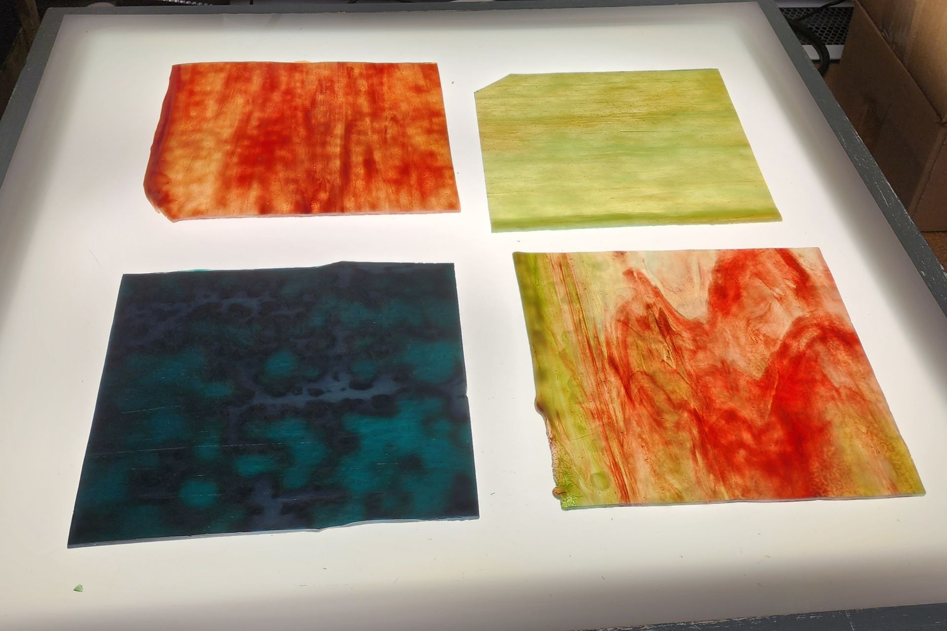 Dark, deep blue and turquoise glass with mottling and streaky red and green Chicago Art Glass Sheets. 