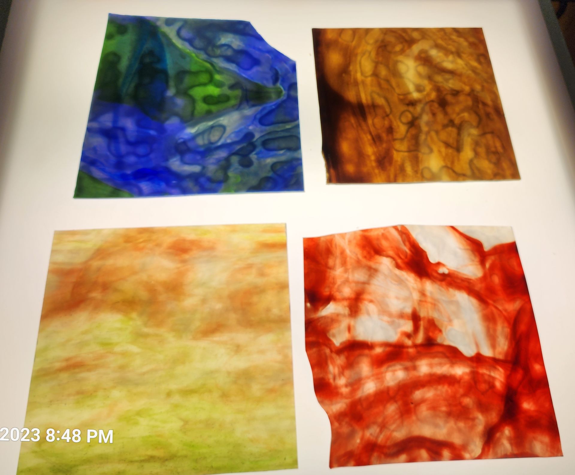 Ocean blue and green stained glass sheet with Chicago Art Glass sheets in shades of red, brown and yellow. 