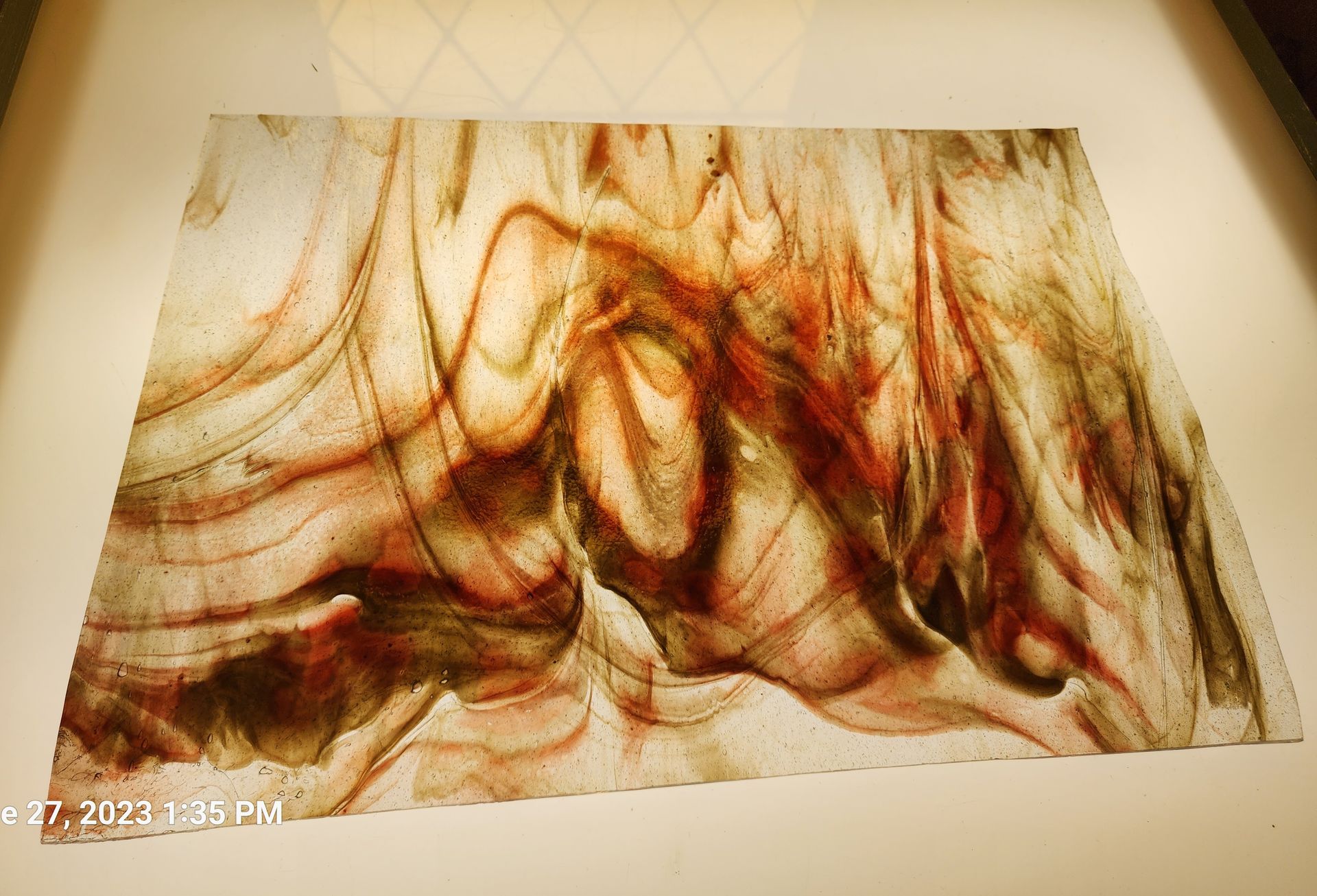 Chicago Art Glass sheet glass with reddish brown swirl on clear background. 