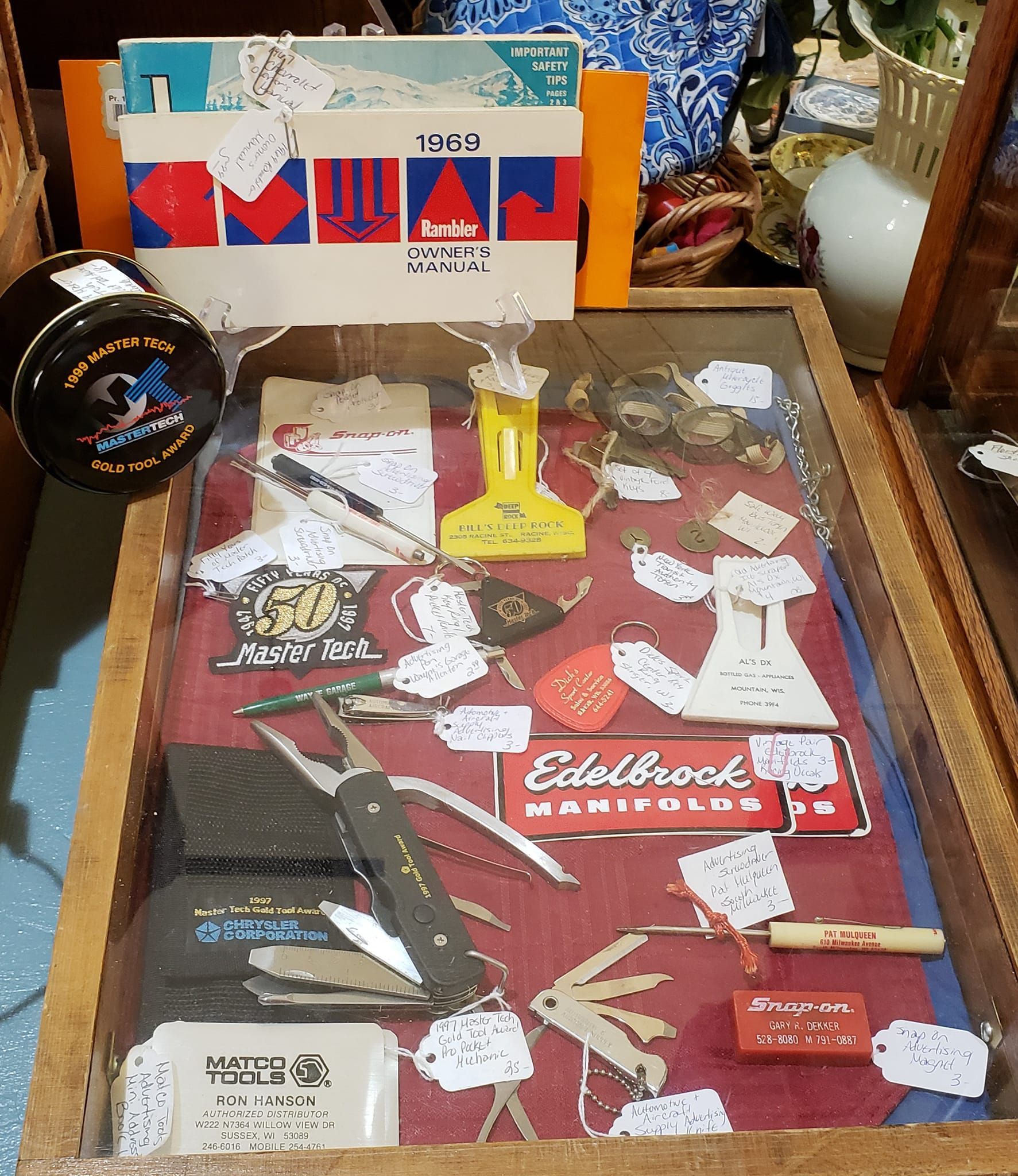 Show case with various automotive collectibes--pocket knives, transportation tokens, Snap On pocket protector-Hartford, WI. 