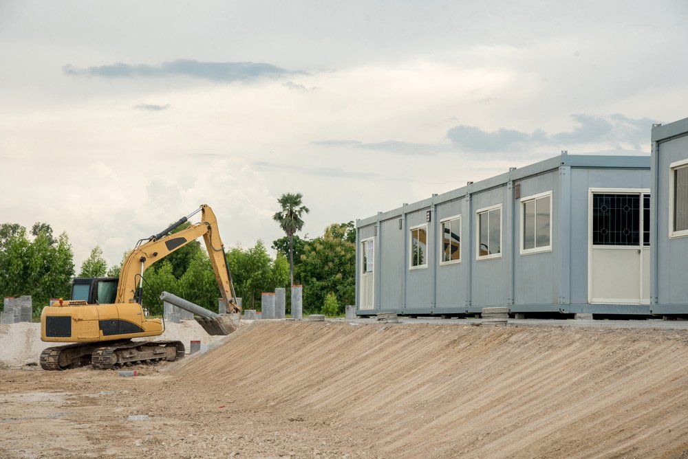 A Yellow Excavator Works on a Dirt Construction Site — East Coast Containers Shipping Containers and Transport in Chevallum, QLD A Yellow Excavator Works on a Dirt — East Coast Containers Shipping Containers and Transport in Chevallum, QLD