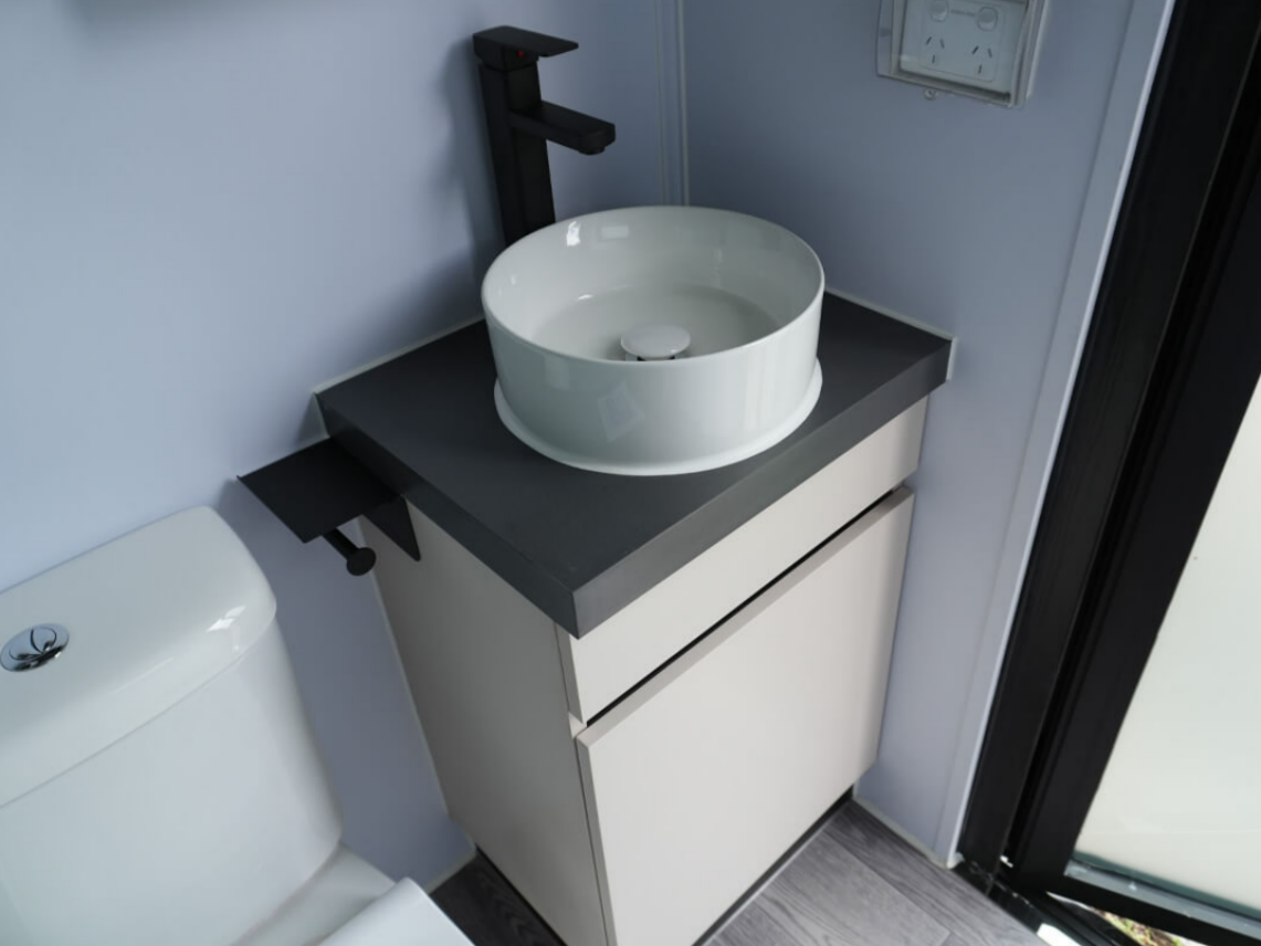 Small Bathroom Vanity With Black Countertop — East Coast Containers Shipping Containers and Transport in Chevallum, QLD