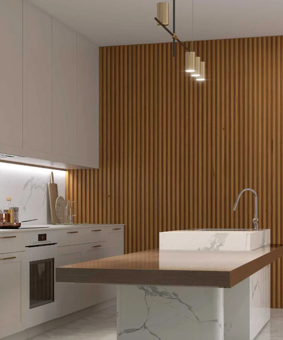 Una cocina moderna con gabinetes blancos, una isla con cubierta de mármol con fregadero y una pared con listones de madera verticales.