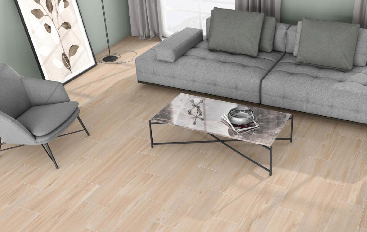 Moderna sala de estar con sofá gris, sillón y mesa de centro de mármol sobre suelo de imitación madera clara.