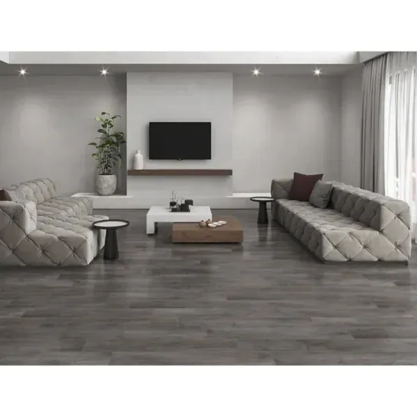 Moderna sala de estar con piso gris, dos grandes sofás beige con mechones, una mesa de centro blanca y de madera y un televisor montado en la pared.