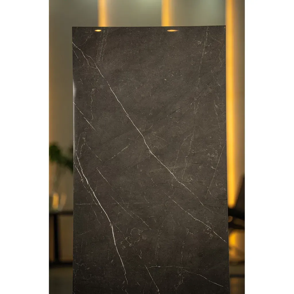 Una baldosa rectangular con una superficie de color gris carbón que presenta vetas finas similares al mármol blanco.