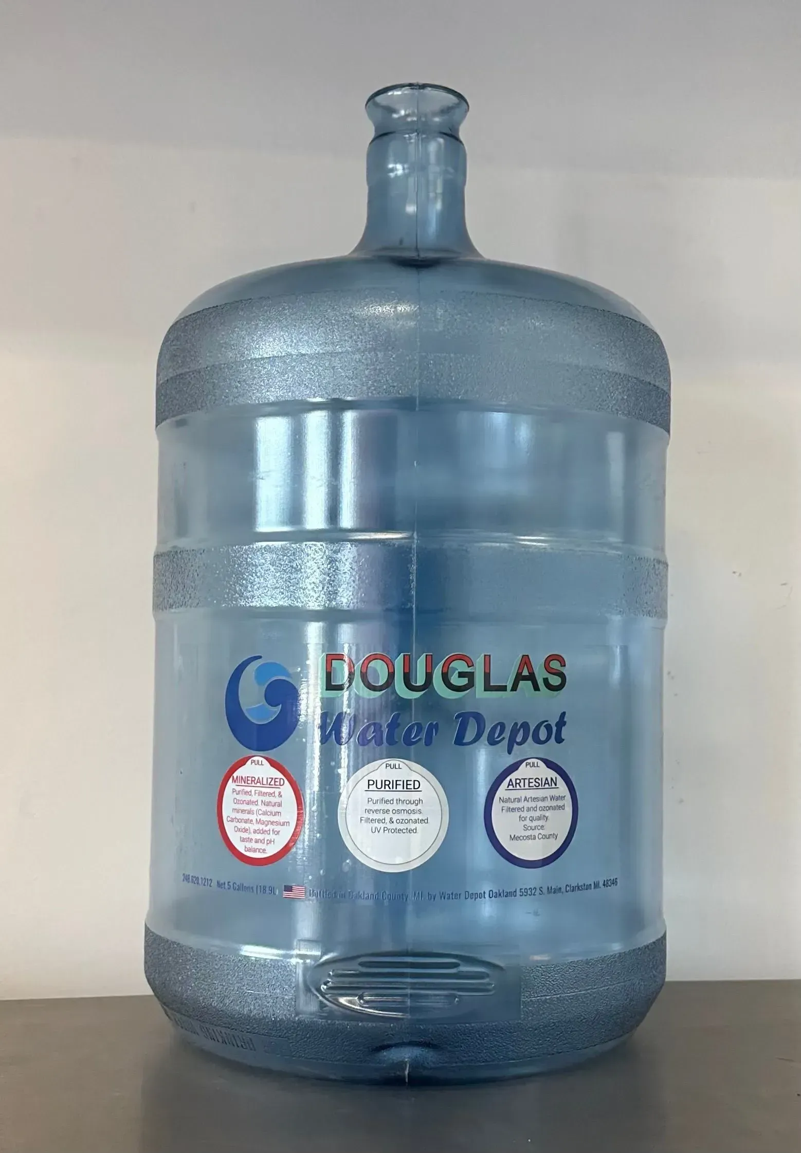 Blue plastic 5-gallon water jug from Douglas Water Depot, sitting on a surface. Blue plastic 5-gallon water jug from Douglas Water Depot, sitting on a surface.